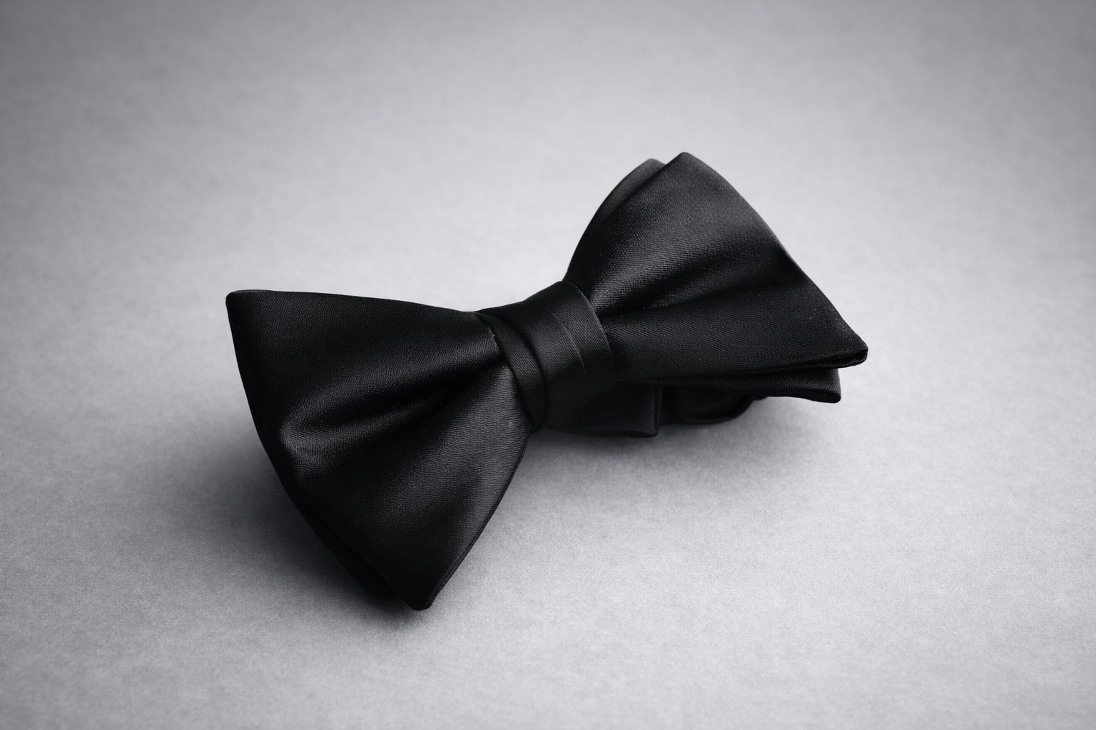 Corbatín negro en satén de acabado liso con brillo sutil — complemento formal para tuxedo y traje de etiqueta — Masculino.do