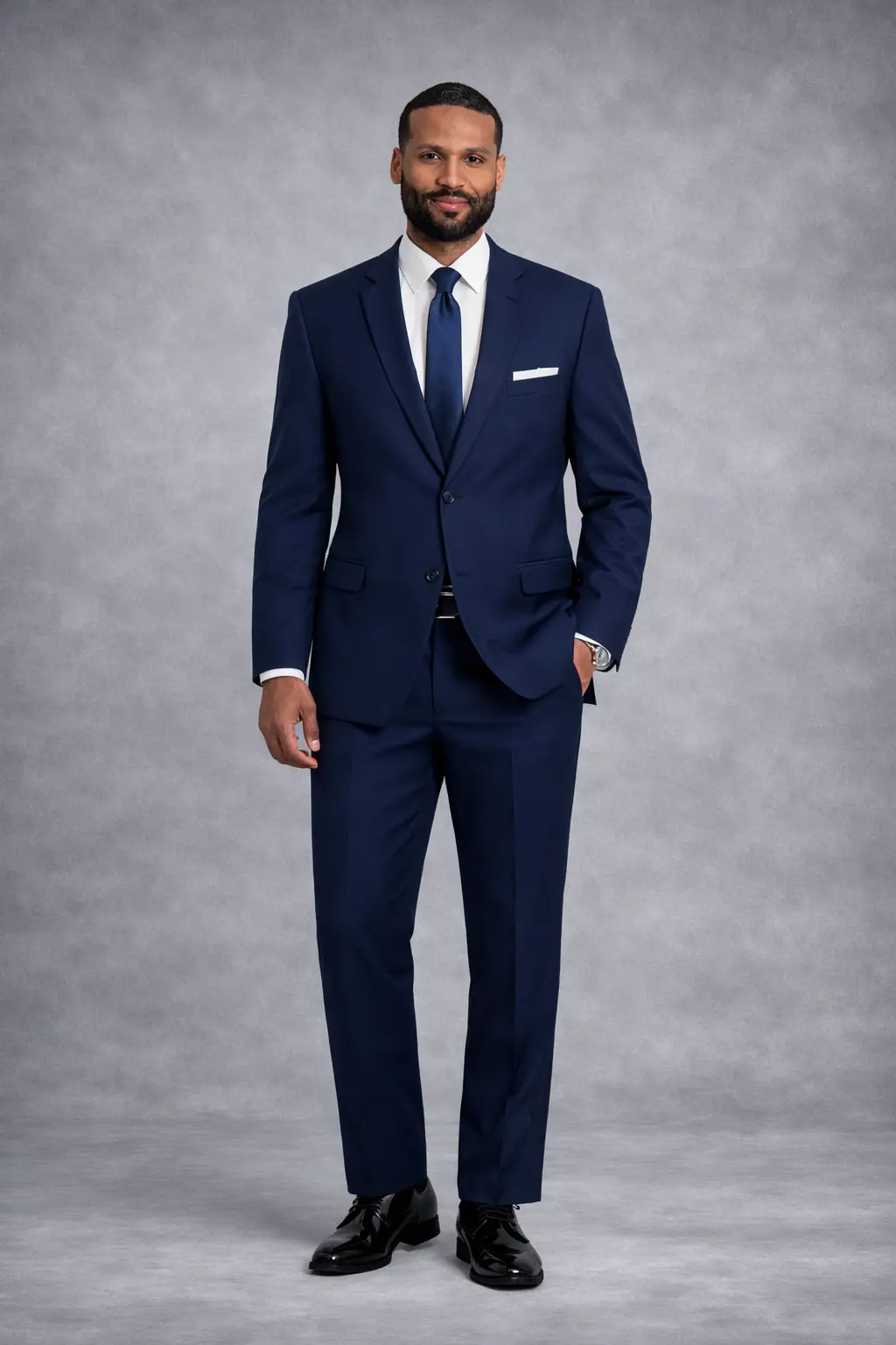 Suit azul navy slim fit con camisa blanca, corbata navy texturizada y pañuelo blanco — look ejecutivo pose relajada cuerpo completo fondo gris — Masculino.do
