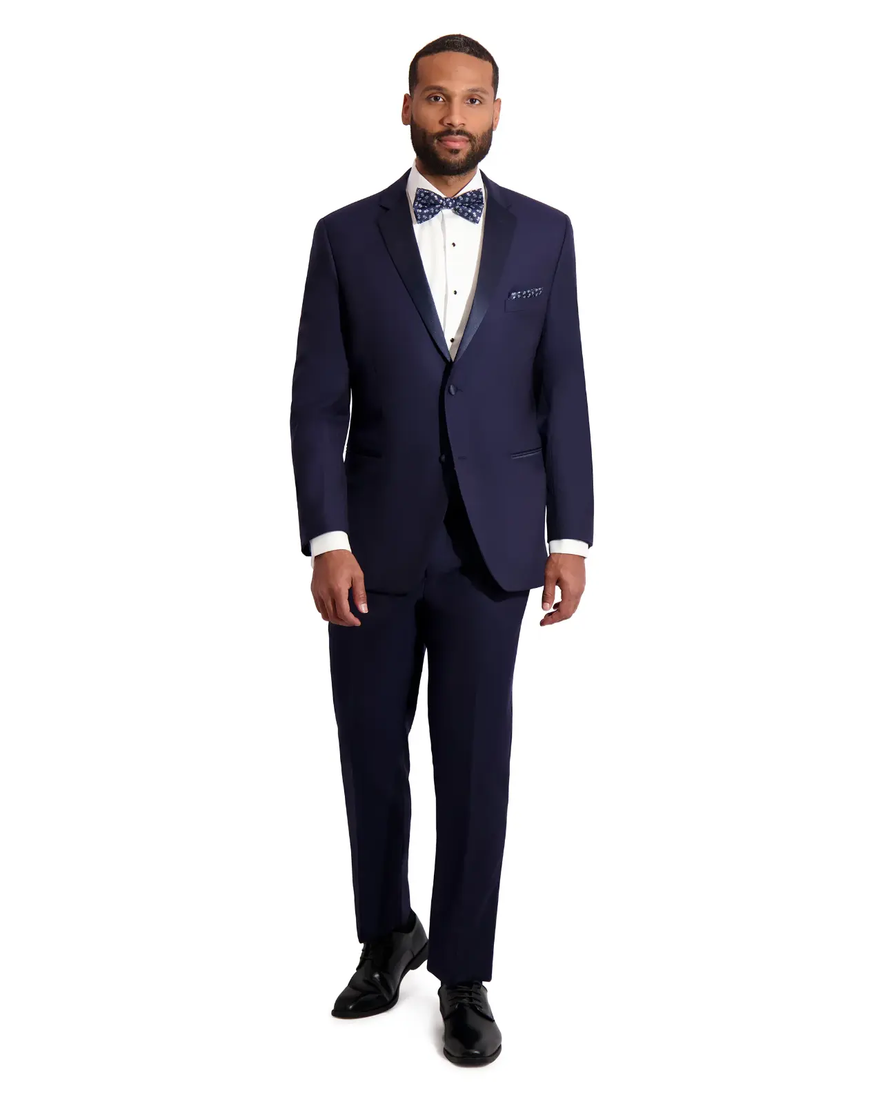 Tuxedo Barcelona Blue slim fit con solapa peak ribeteada en satín, corbatín estampado azul, pañuelo de bolsillo y zapatos negros, cuerpo completo fondo blanco — Masculino.do