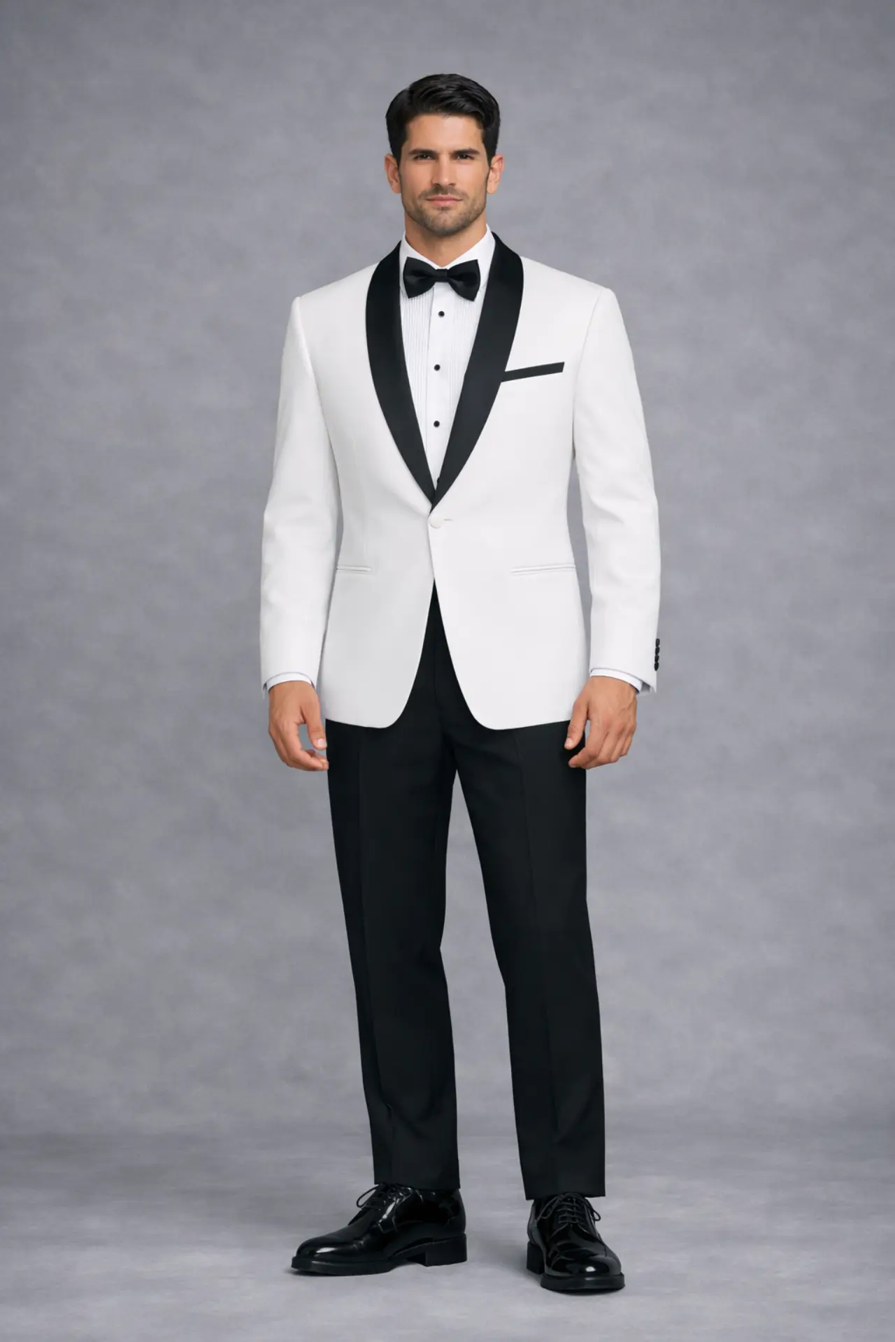 Dinner jacket blanco con solapa shawl en satín negro, corbatín negro, pantalón negro y zapatos de charol, cuerpo completo fondo gris — Masculino.do