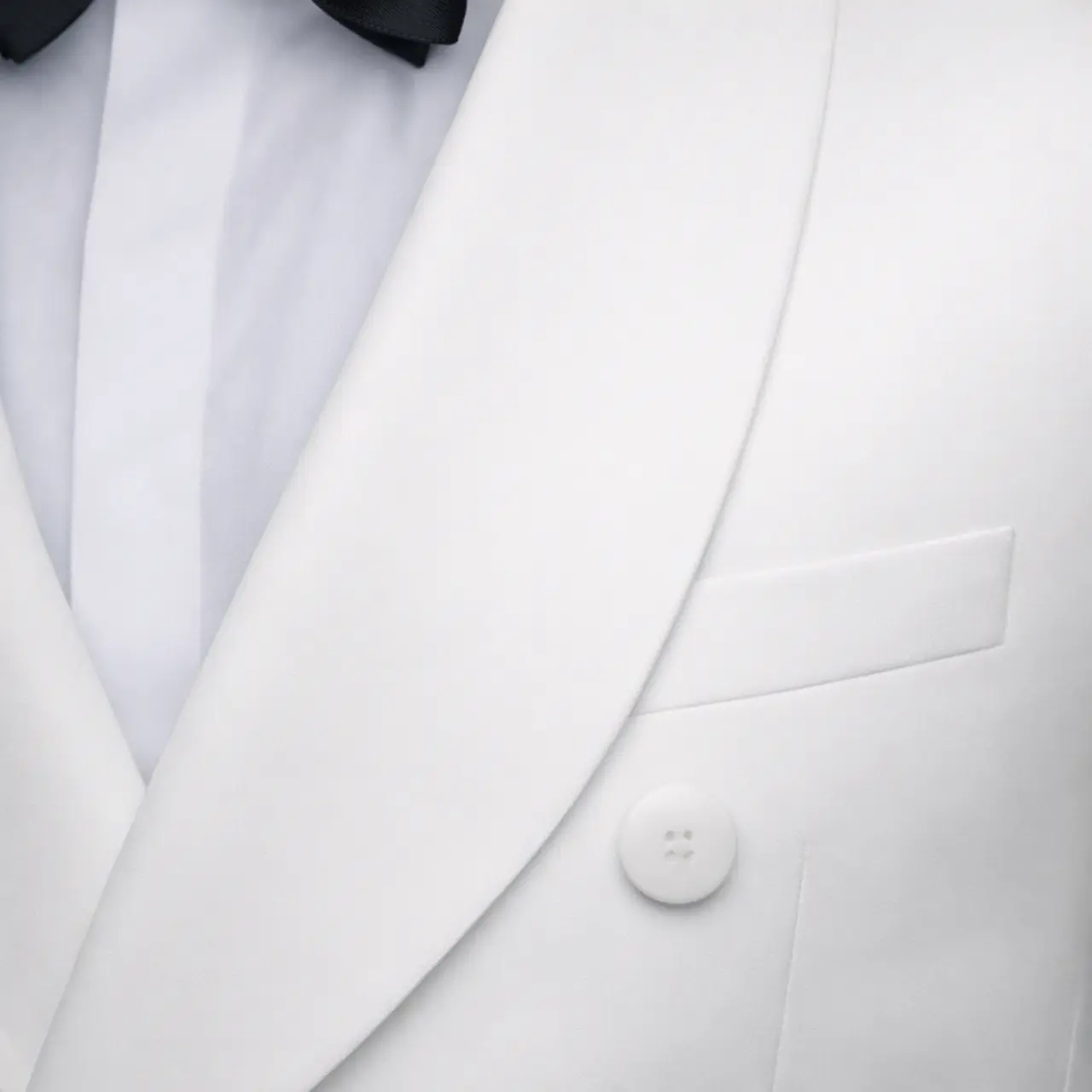 Detalle de dinner jacket blanco cruzado con solapa shawl en satín blanco, botón forrado y bolsillo de pecho, primer plano — Masculino.do
