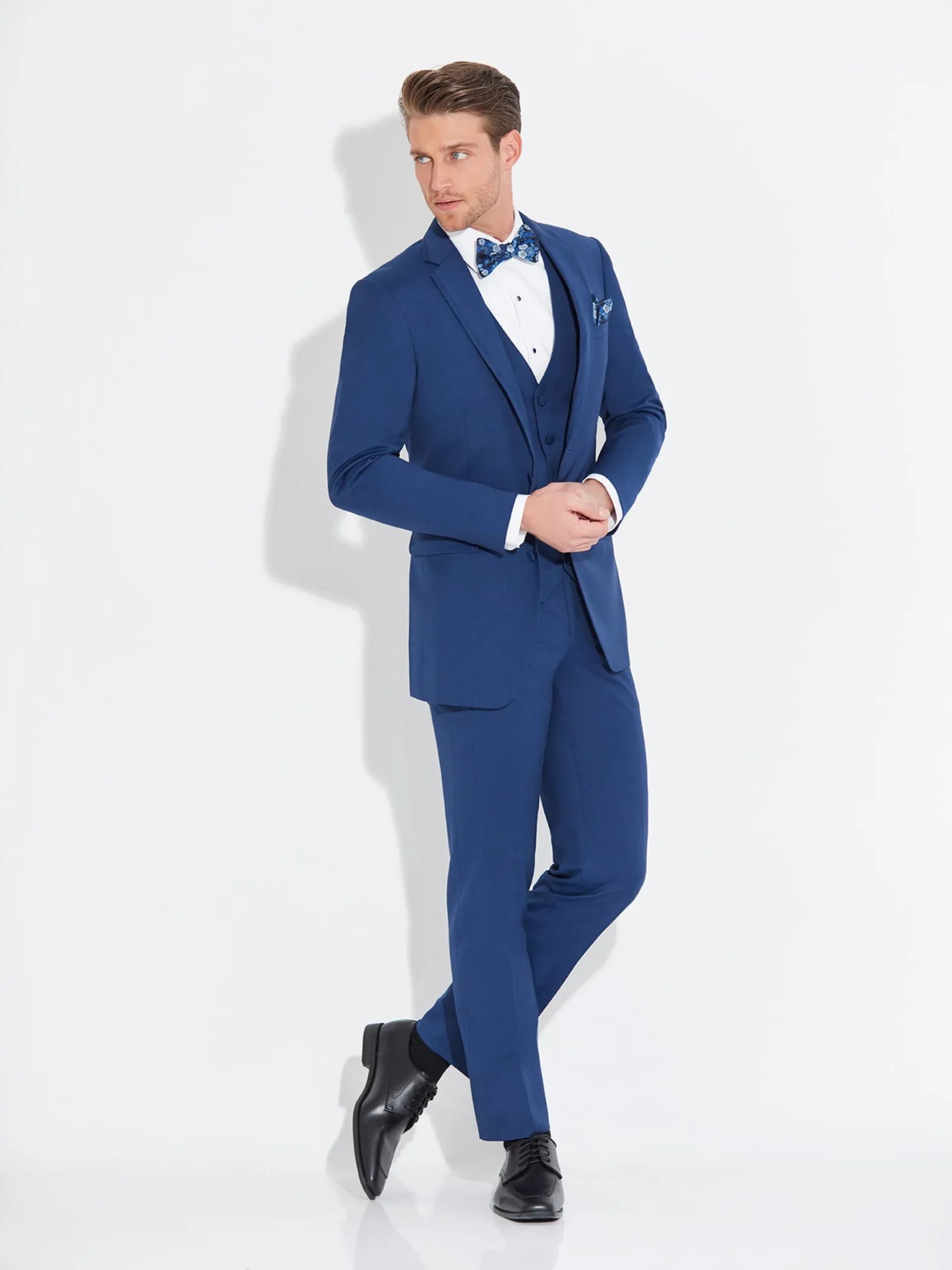 Traje azul cobalto de tres piezas slim fit con chaleco, corbatín floral azul y pañuelo de bolsillo, cuerpo completo fondo blanco — Masculino.do