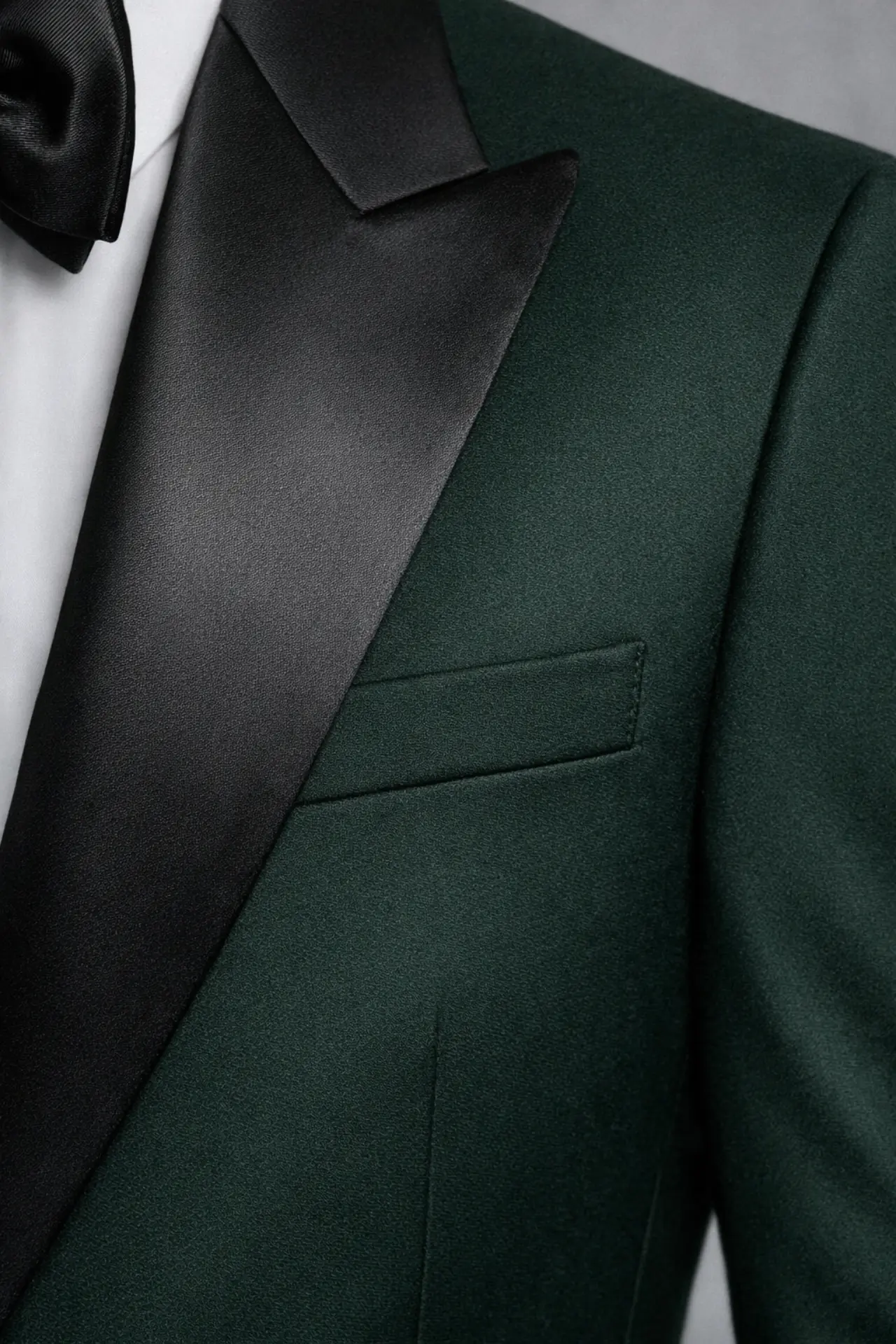 Primer plano de solapa Peak en satín negro sobre tejido verde esmeralda del Tuxedo Cooper Green — detalle de contraste textural — Masculino.do