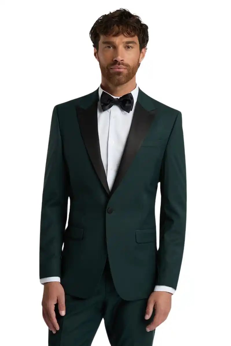 Tuxedo verde esmeralda slim fit con solapa peak en satín negro, camisa blanca y corbatín negro, fondo oscuro — venta y renta en Masculino.do