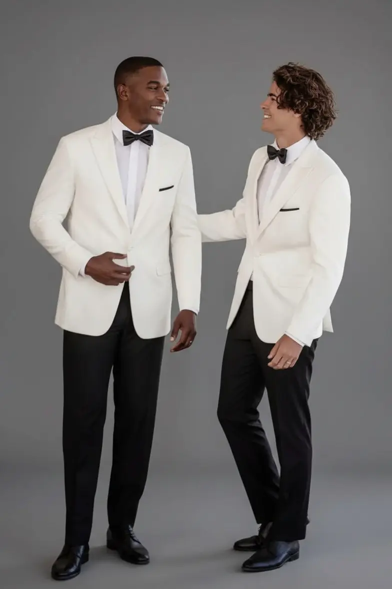 Dos hombres con esmoquin marfil solapa peak, pantalón negro y corbatín negro, cuerpo completo — Masculino.do