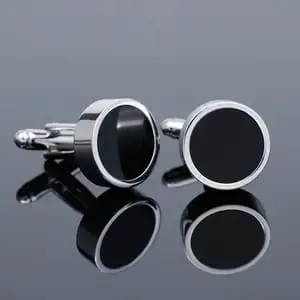 Set de gemelos y pasadores de camisa con acabado plateado e incrustación gris oscuro sobre superficie de cristal, accesorios formales para hombre