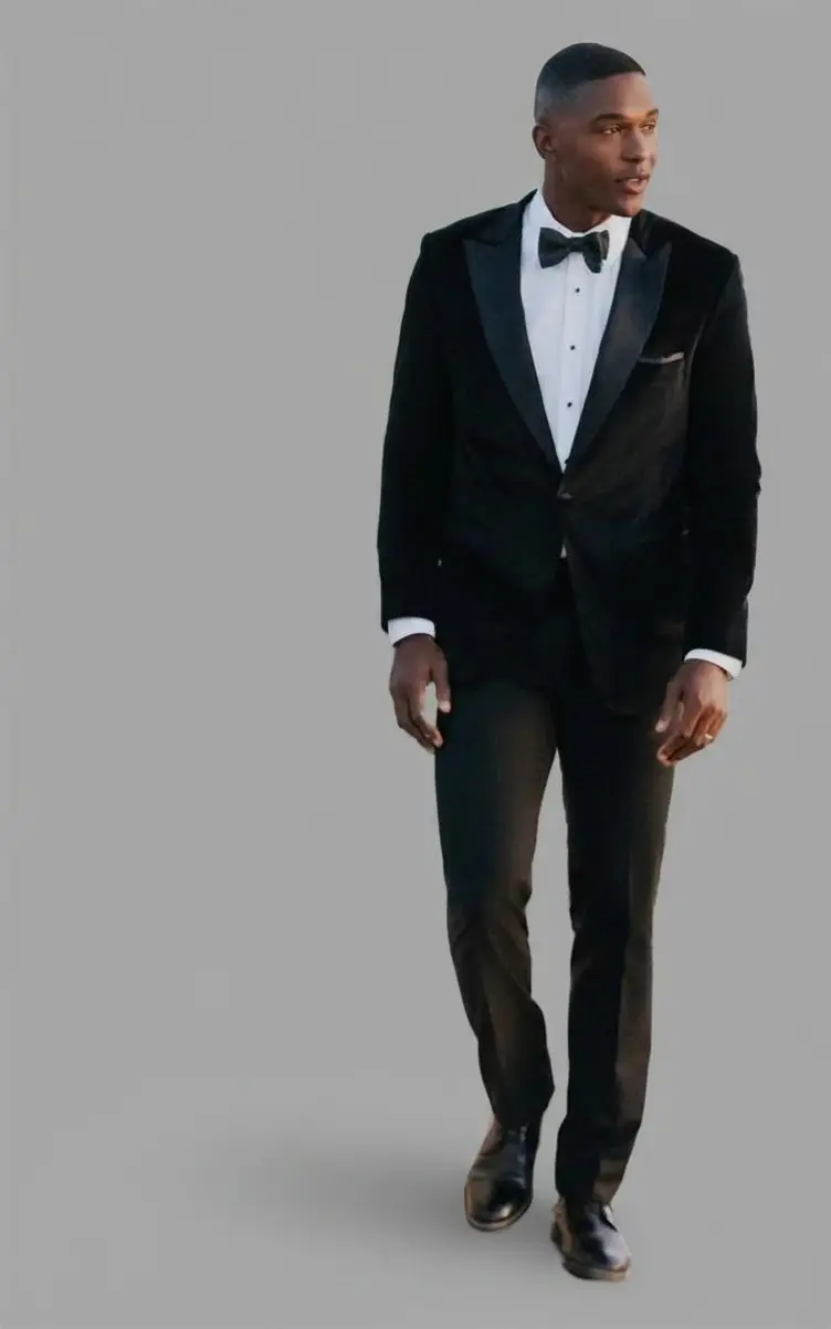 Esmoquin negro de terciopelo con solapa peak, camisa blanca, corbatín negro y zapatos de charol, frente completo — Masculino.do