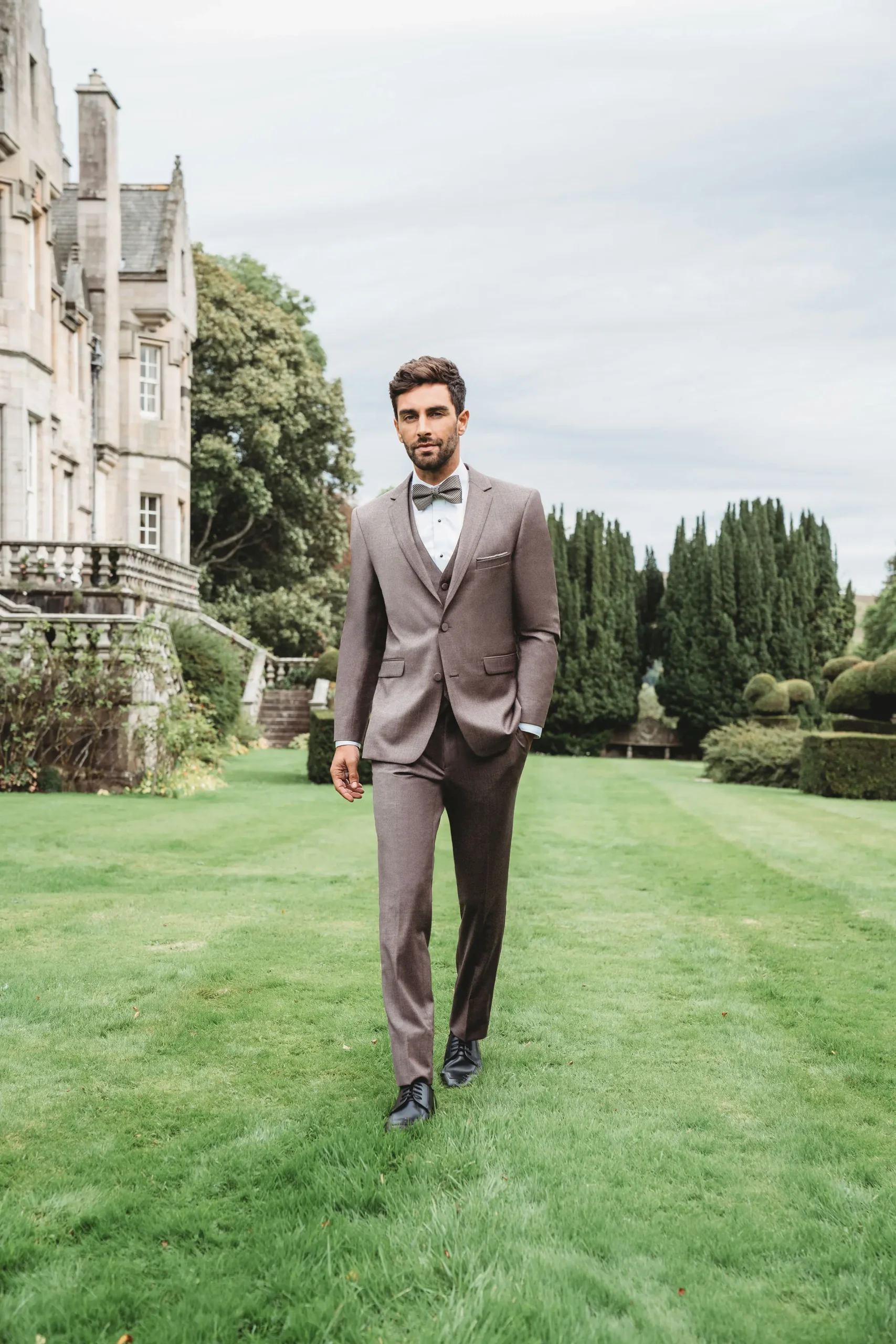 Suit Mulberry tres piezas con chaleco tono sobre tono y corbatín gris en jardín de hacienda — look de novio al aire libre exterior — Masculino.do