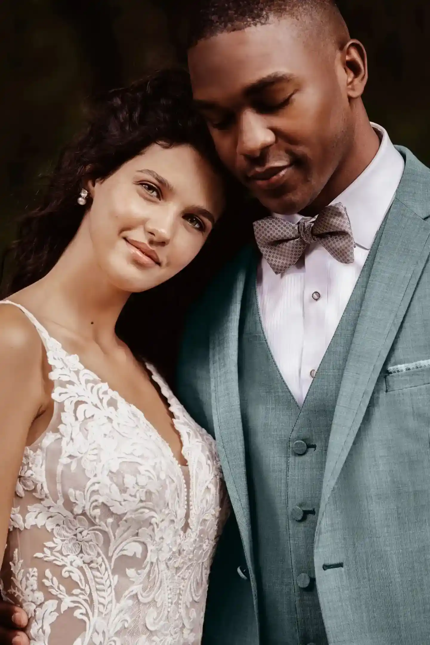 Pareja de novios: él con traje verde sage de tres piezas con chaleco y corbatín, ella con vestido de novia de encaje, primer plano — alquiler en Masculino.do