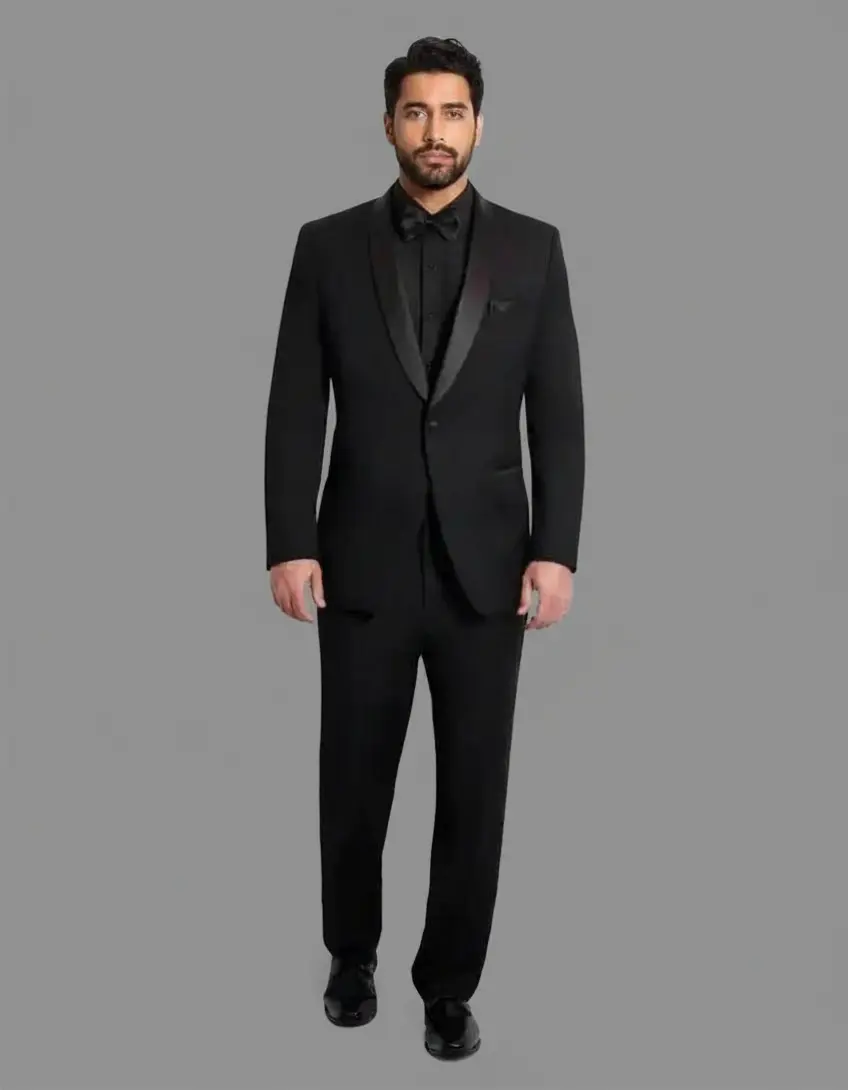 Tuxedo Seville negro con solapa shawl en satín negro, camisa negra, corbatín negro satinado y zapatos negros — look total black cuerpo completo fondo gris — Masculino.do