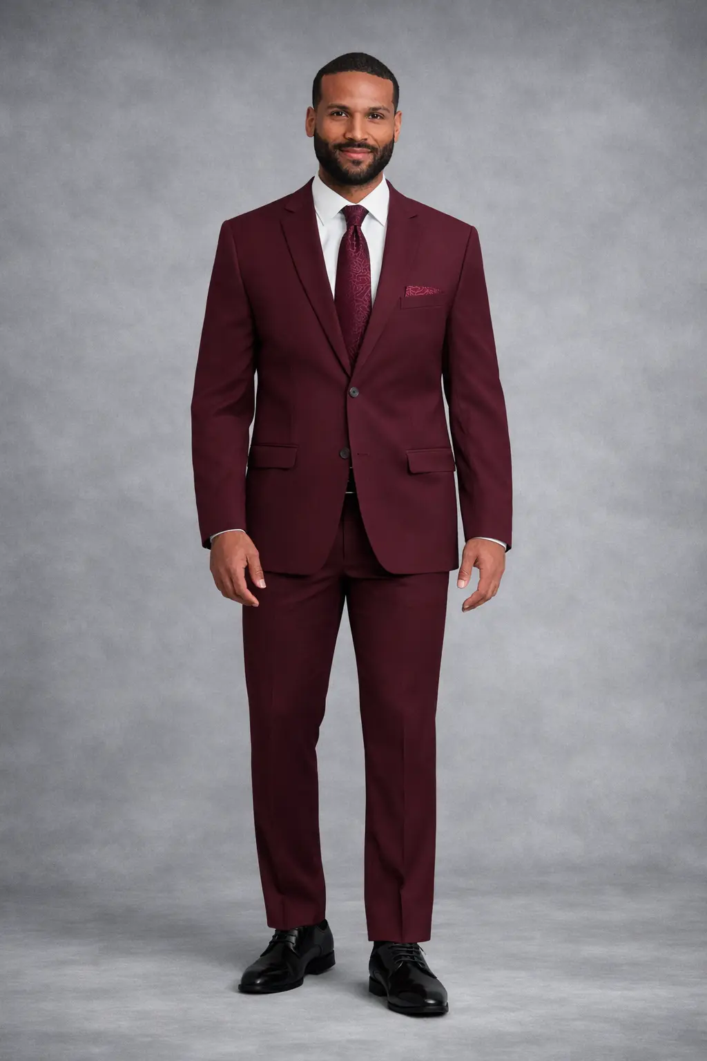 Suit burgundy slim fit de dos piezas con camisa blanca, corbata estampada borgoña y pañuelo de bolsillo — cuerpo completo fondo gris — Masculino.do